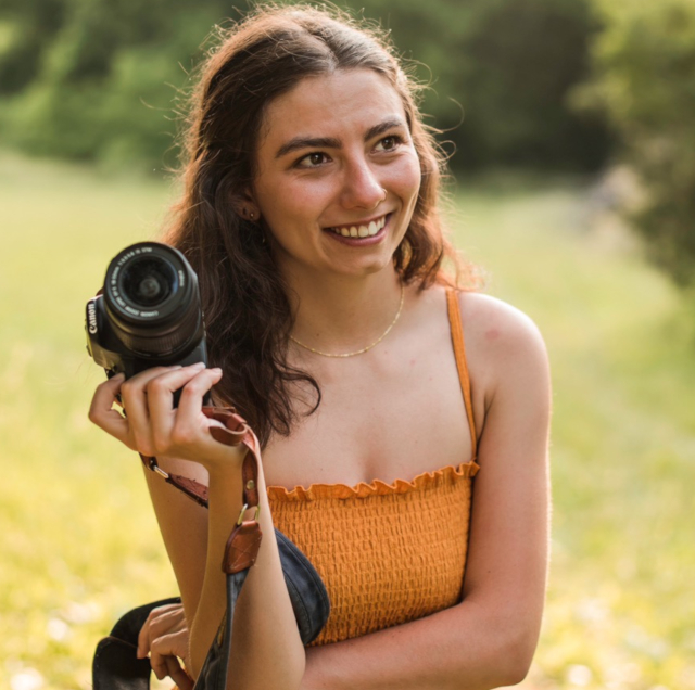 Capturing Moments: A photographer taking a shot against the serene beauty of a deep blue lake.